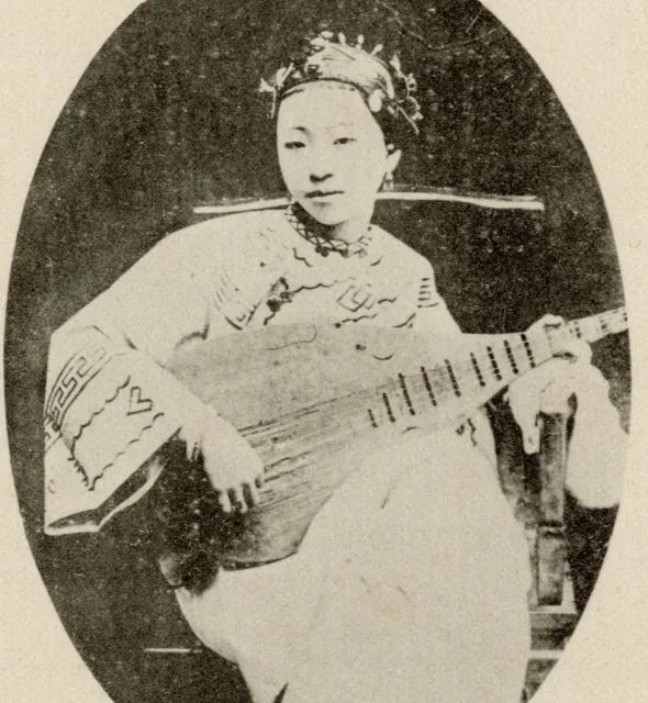 約 1916 年《臺灣寫真帖》裡抱著琵琶的藝旦;從清初〈臺灣賦〉起,琵琶就是台灣市井娛樂裡的撥弦樂器。