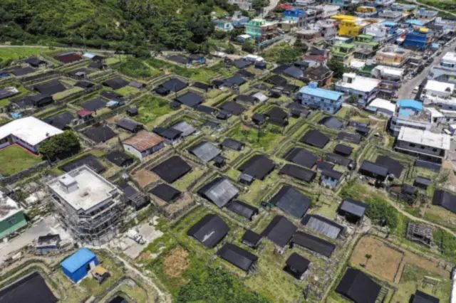 從空中看蘭嶼野銀部落倚山面海的傳統地下屋聚落,拍手歌會就在這樣的家屋旁的高屋裡舉行