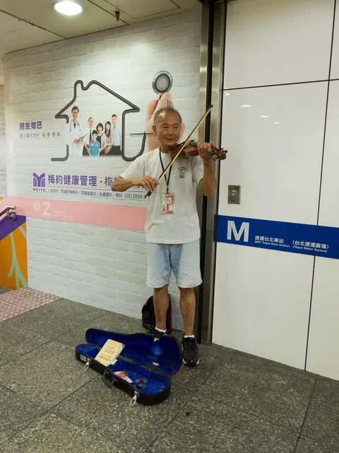 2014 年 7 月，台北車站捷運廣場裡拉小提琴的街頭藝人