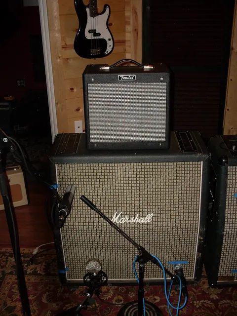 錄音室裡把一台小音箱接到裝綠背喇叭的 Marshall 喇叭箱；同一顆音箱頭換不同喇叭，聲音就會變