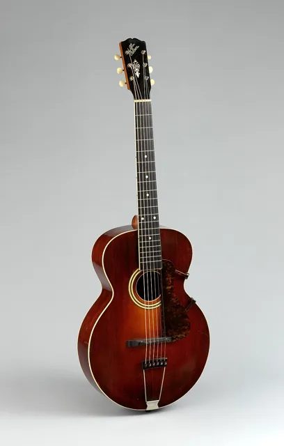 Gibson 公司約 1917 年製作的 L-3 拱面吉他(序號 32544),延續奧維爾的雕刻面板與橢圓音孔設計,大都會藝術博物館收藏