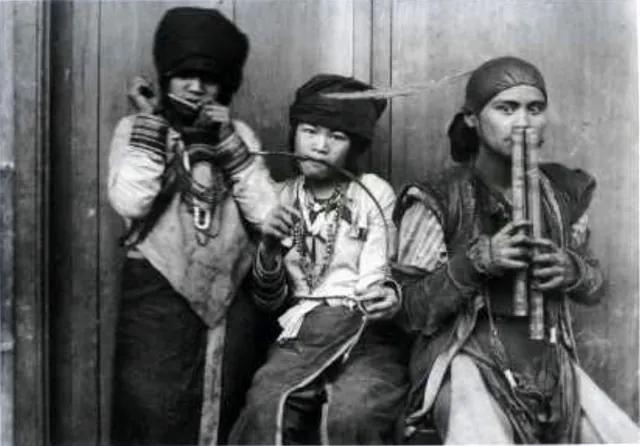 1907 年伊能嘉矩發表的照片:三位鄒族人,左邊的人把口簧放在嘴邊、中間的少年咬著一張弓琴、右邊吹雙管笛。