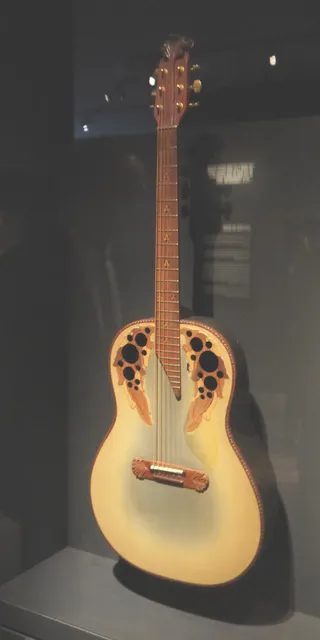 Ovation 在 1978 年替哈特樂團吉他手南西·威爾森特製的 Adamas,2019 年在大都會藝術博物館的搖滾樂器展展出,圓背加內建拾音器是那個年代的舞台面貌